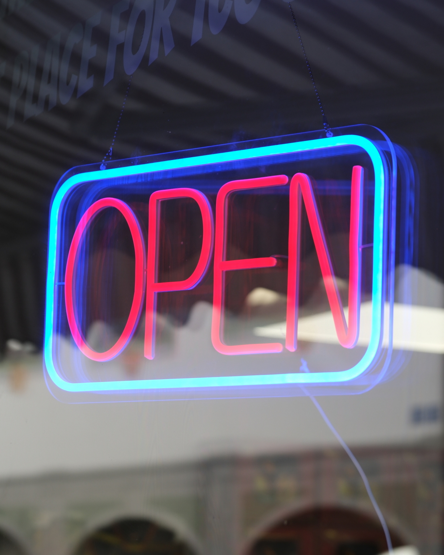 Neon-Leuchtschild mit OPEN-Schriftzug an Schaufenster – Symbol für offenen TCG-Shop Trinket Mage in Garmisch-Partenkirchen