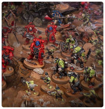 Warhammer 40.000 Armageddon Spielszene mit Space Marines und Orks im Gefecht auf einem Schlachtfeld