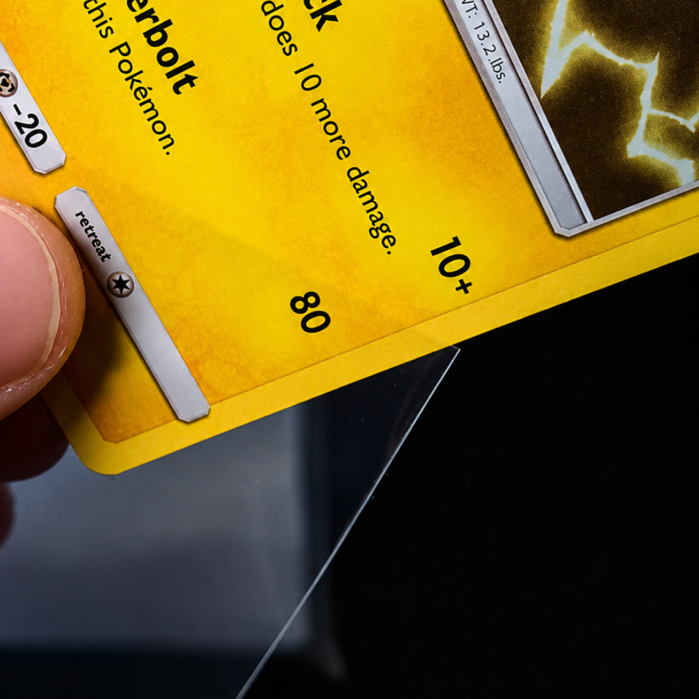 Detailaufnahme einer Pokémon Sammelkarte beim Einführen in eine transparente Schutzhülle.