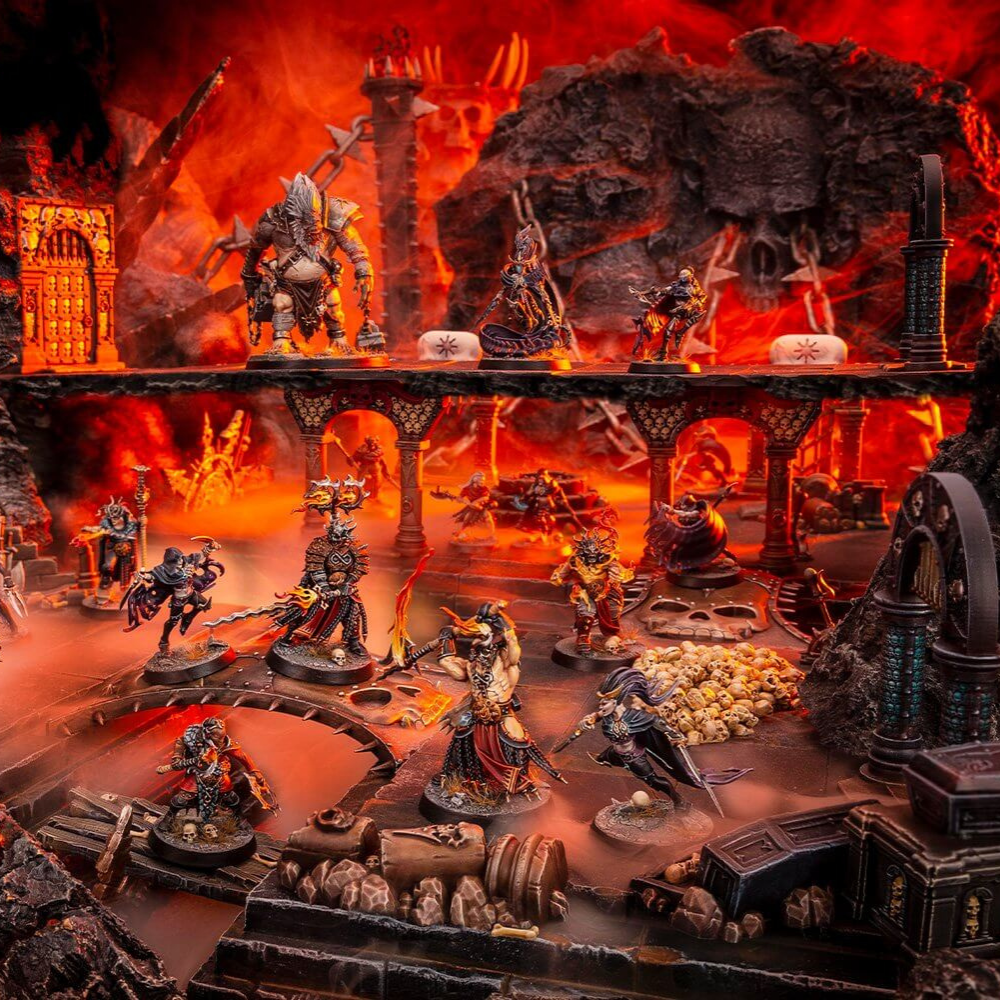 Warhammer-Miniaturen stehen auf einem detailreichen Fantasy-Gelände mit Lava, Ruinen und Felsformationen.